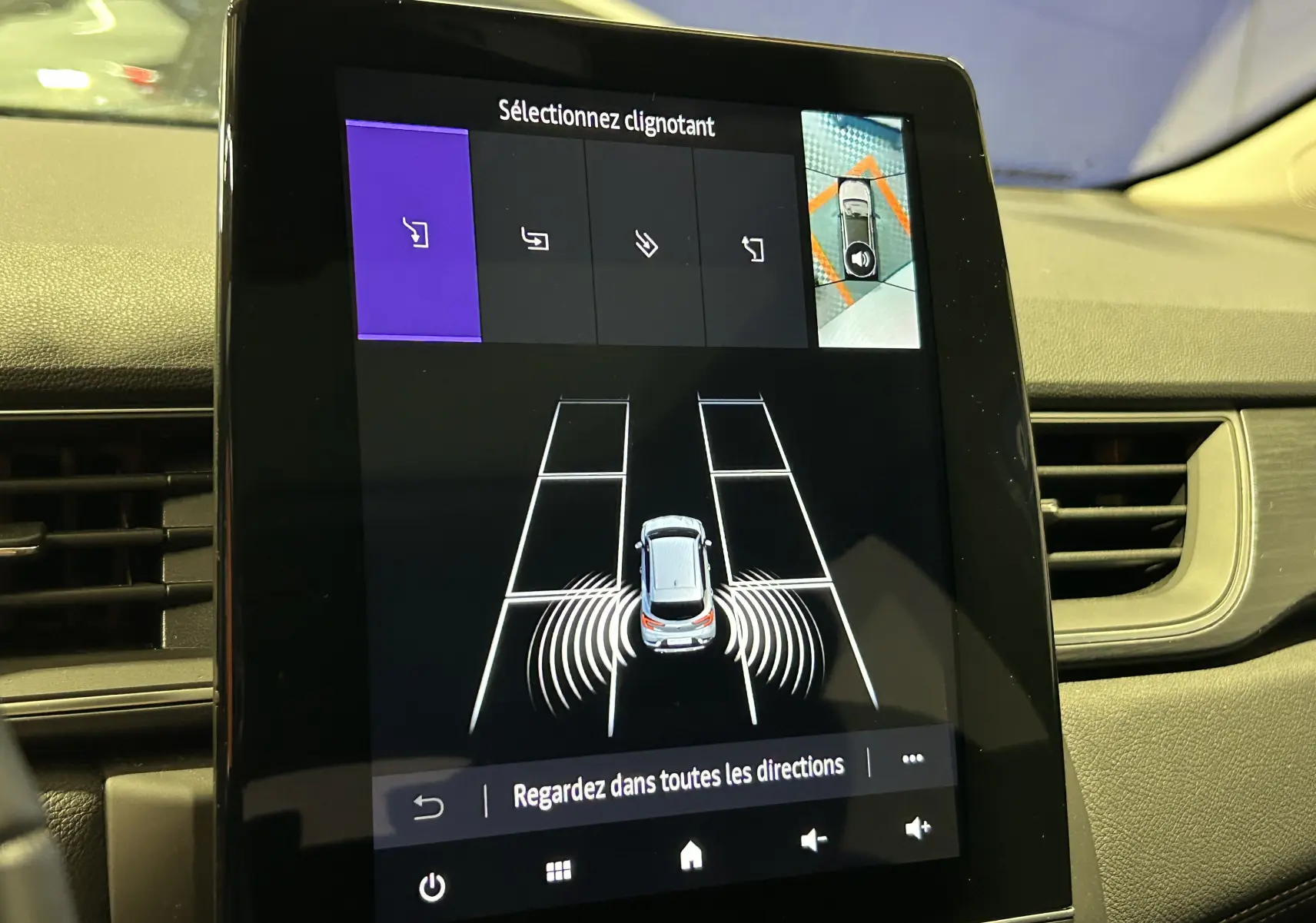 Écran tactile intérieur du Renault Captur blanc nacré 2022 montrant l'aide au stationnement avec caméra 360° et sélection du clignotant.