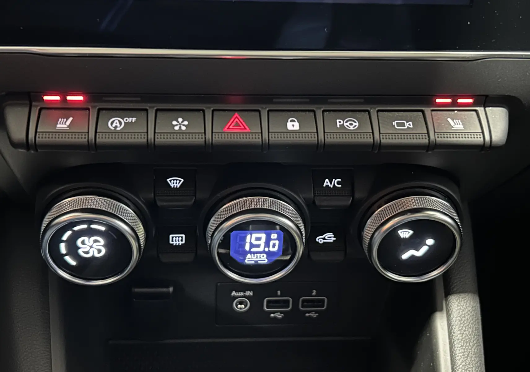 Tableau de bord du Renault Captur II Iconic 2022, zoom sur commandes climatisation et boutons fonctionnels avec affichage digital bleu.