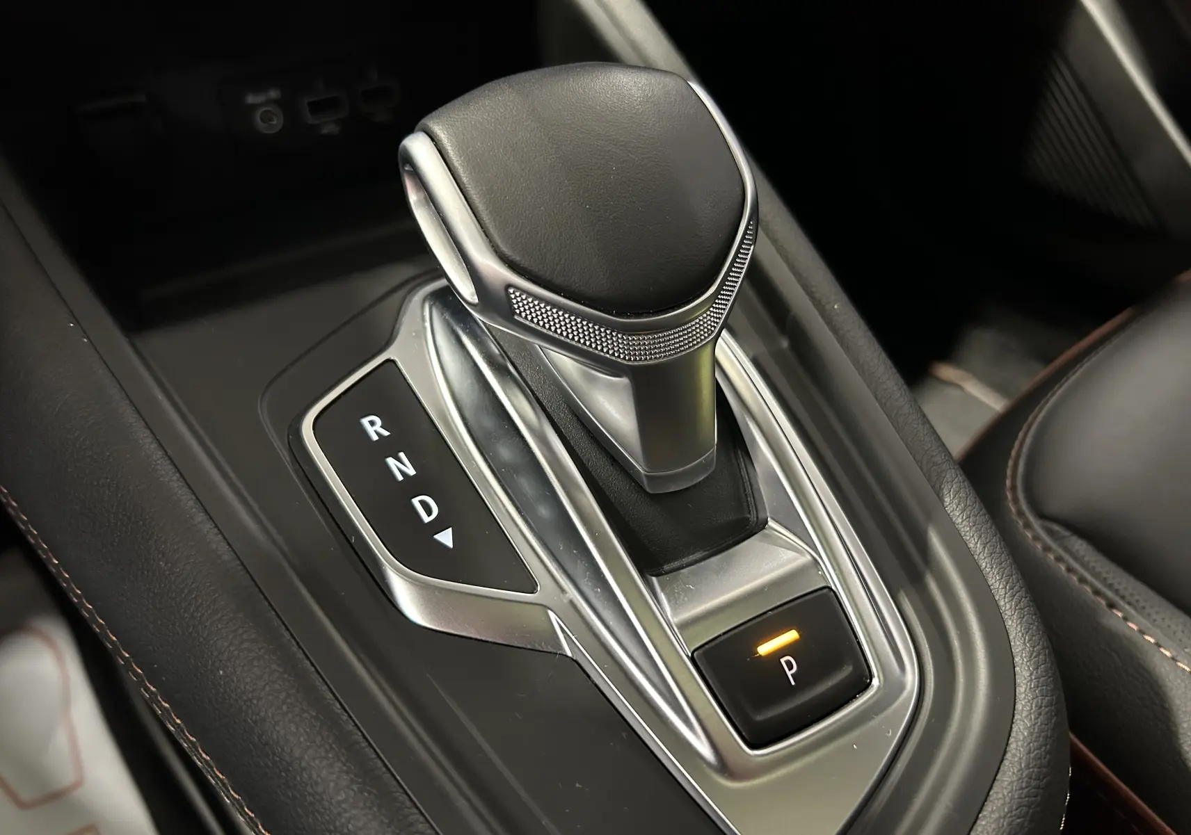 Le levier de vitesses automatique en cuir noir du Renault Captur II Iconic, vue rapprochée de la console centrale.