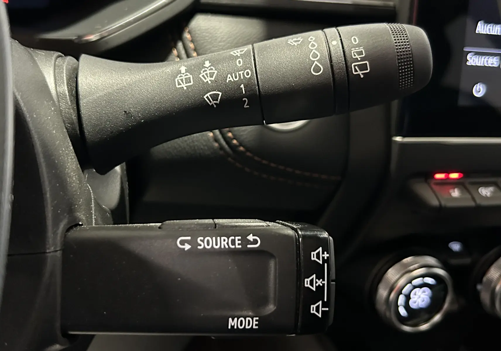 Gros plan sur les commandes au volant du Renault Captur blanc nacré 2022, avec boutons source et mode visibles.