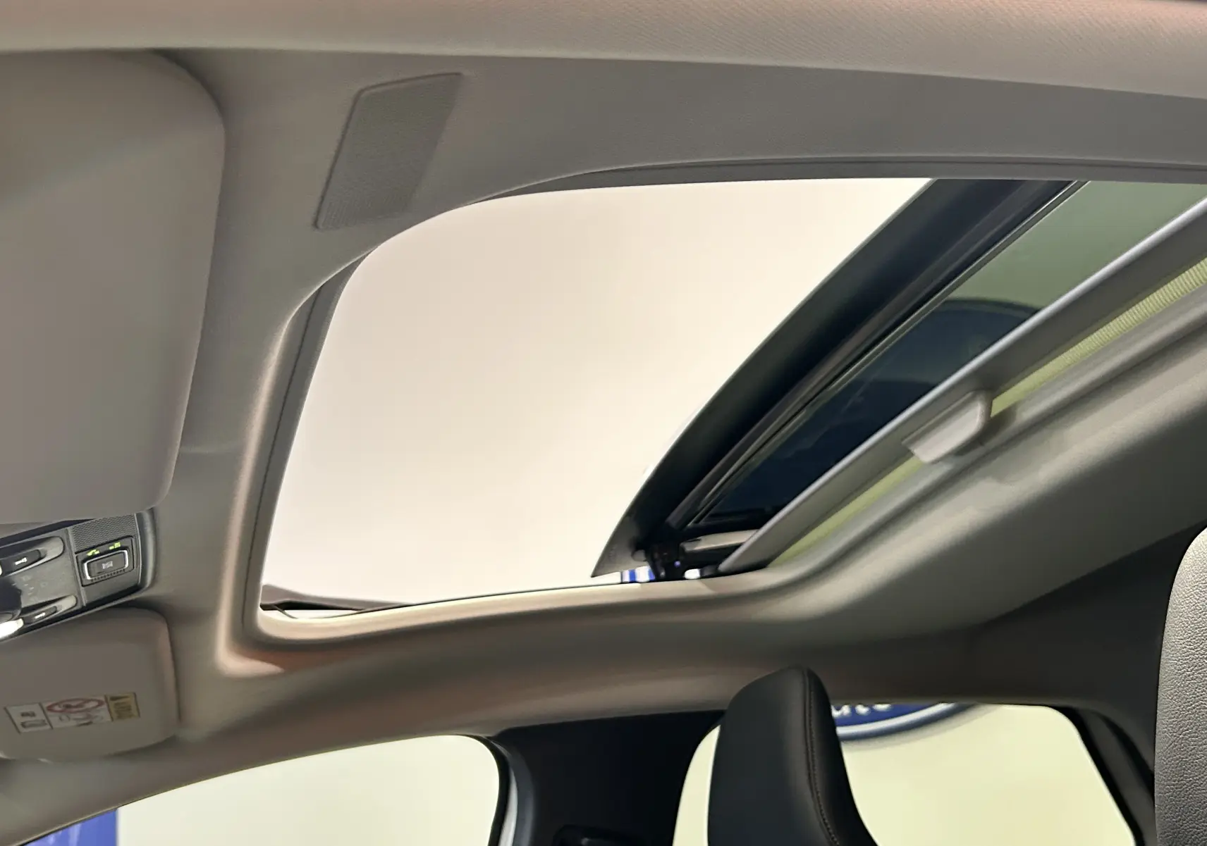 Toit ouvrant panoramique ouvert sur l'intérieur du Renault Captur II Iconic blanc nacré, vue depuis l'avant droit.