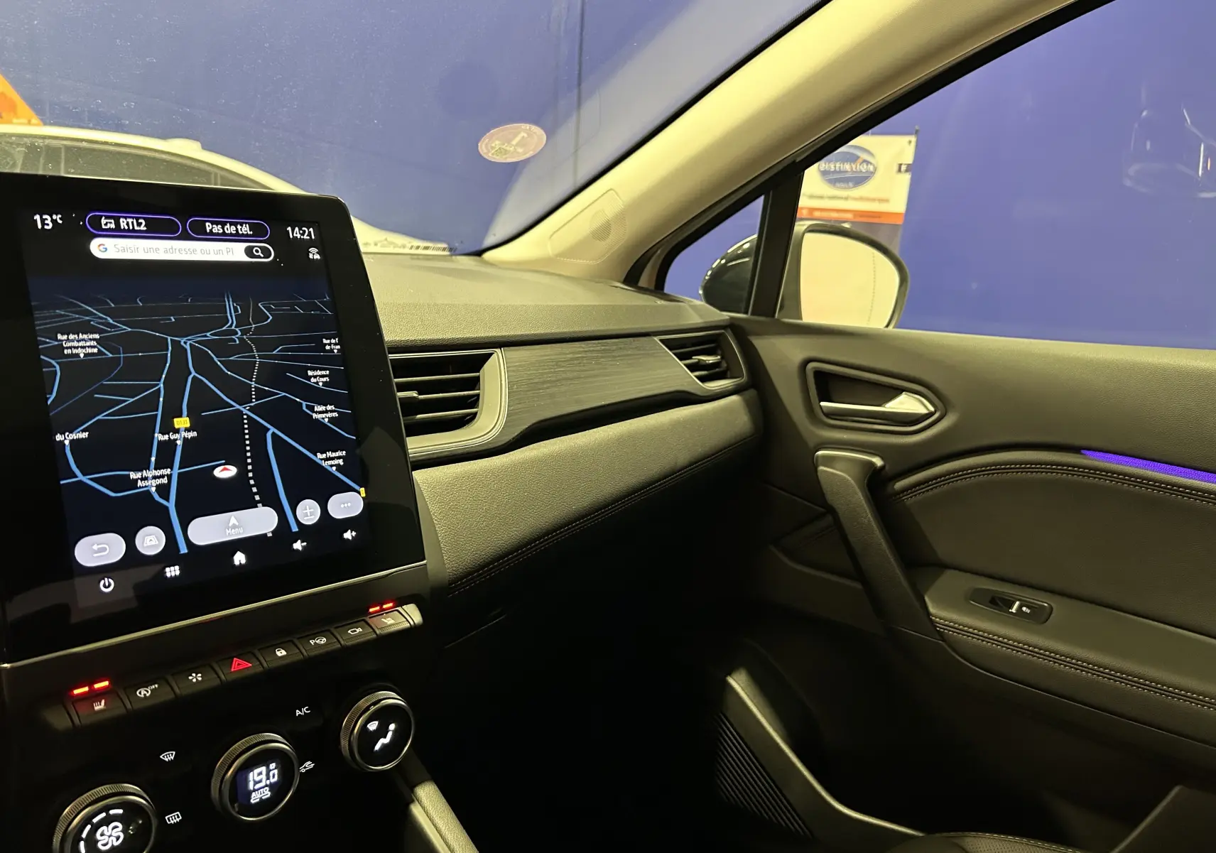 Vue intérieure côté passager du tableau de bord et de la porte du Renault Captur blanc nacré avec écran tactile et éclairage d'ambiance violet