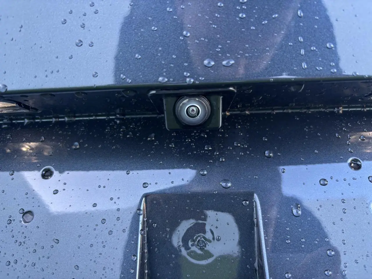 Gros plan sur la caméra de recul intégrée sur la malle arrière gris magnetic d'une SEAT LEON 2024.