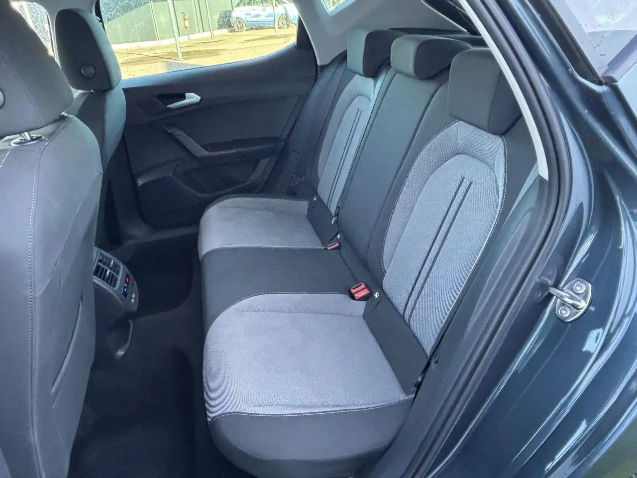 Vue côté droit de la banquette arrière bi-ton gris clair et foncé du SEAT Leon IV 2024 avec aérateurs et prises USB arrière.