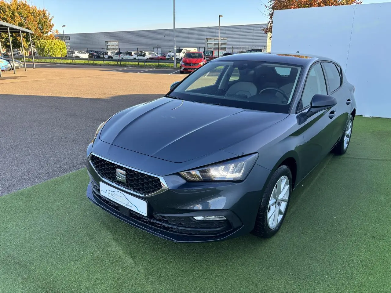 SEAT Leon IV gris magnetic en 3/4 avant droit, avec phares LED allumés et jantes alliage 16 pouces.