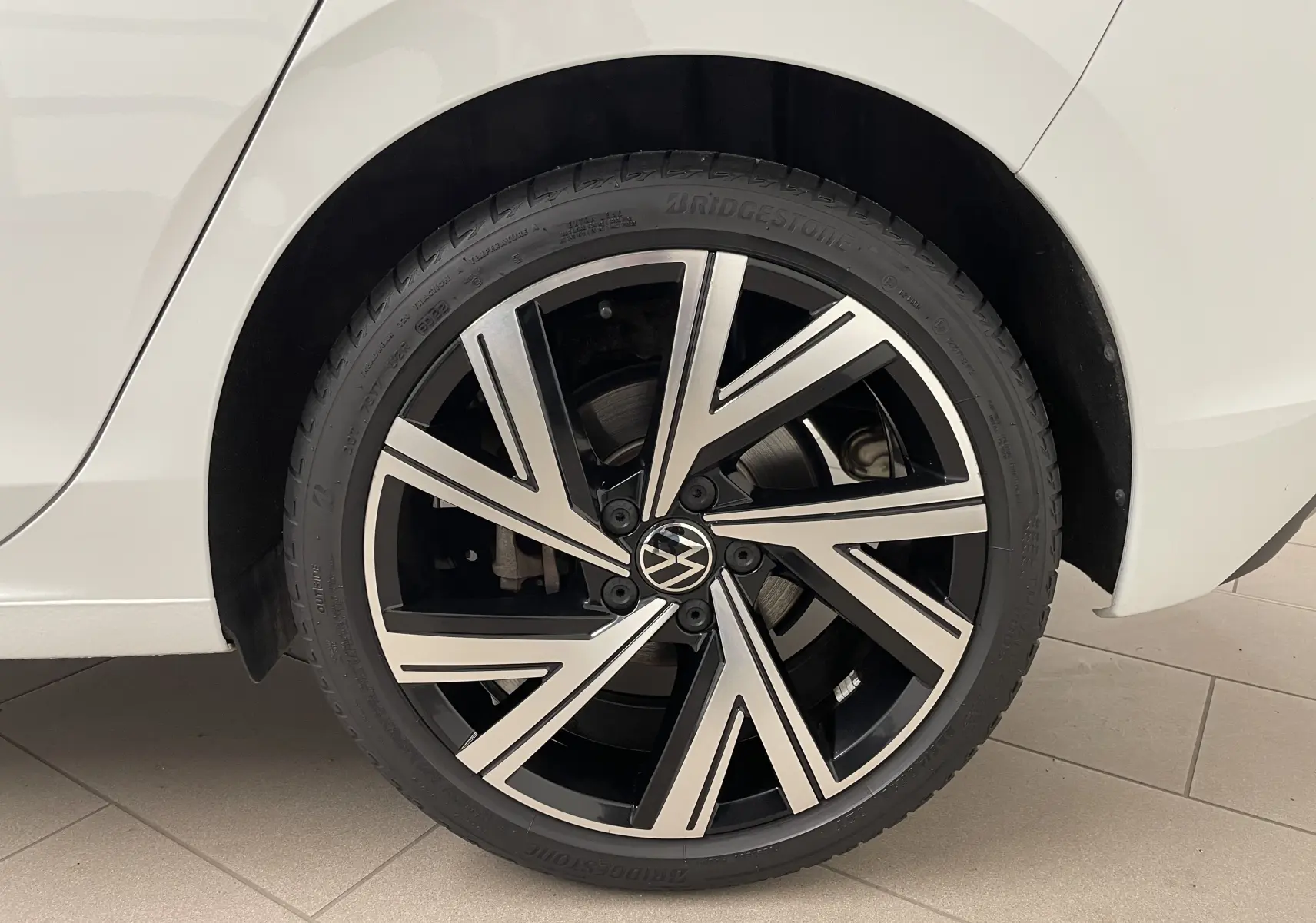 Gros plan sur la jante Bergamo noire et argentée de la roue arrière droite d'une Volkswagen Golf blanche 2023.