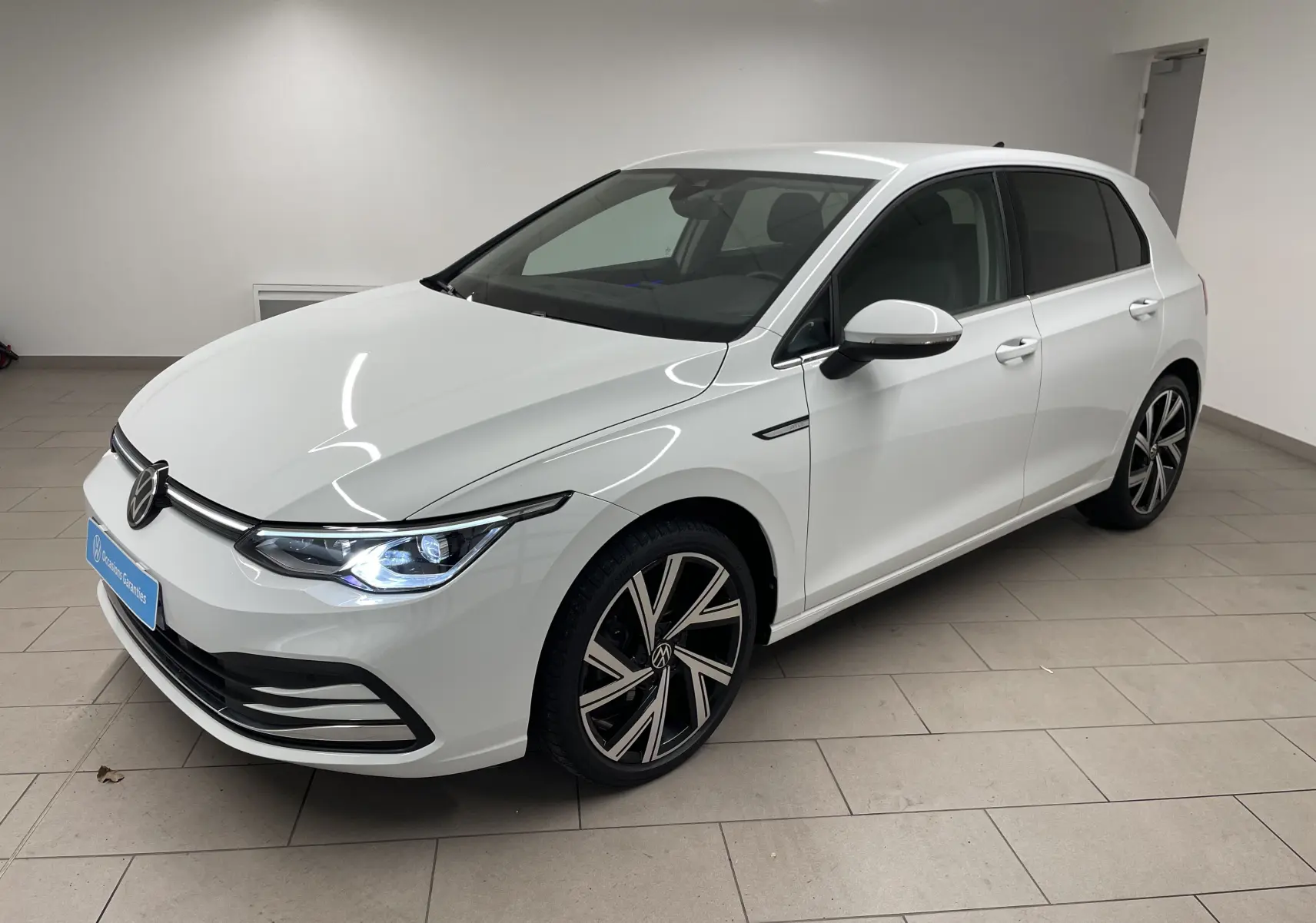 Volkswagen Golf 1.5 eTSI blanc pur vue 3/4 avant droit avec jantes alliage Bergamo et vitres arrière surteintées.