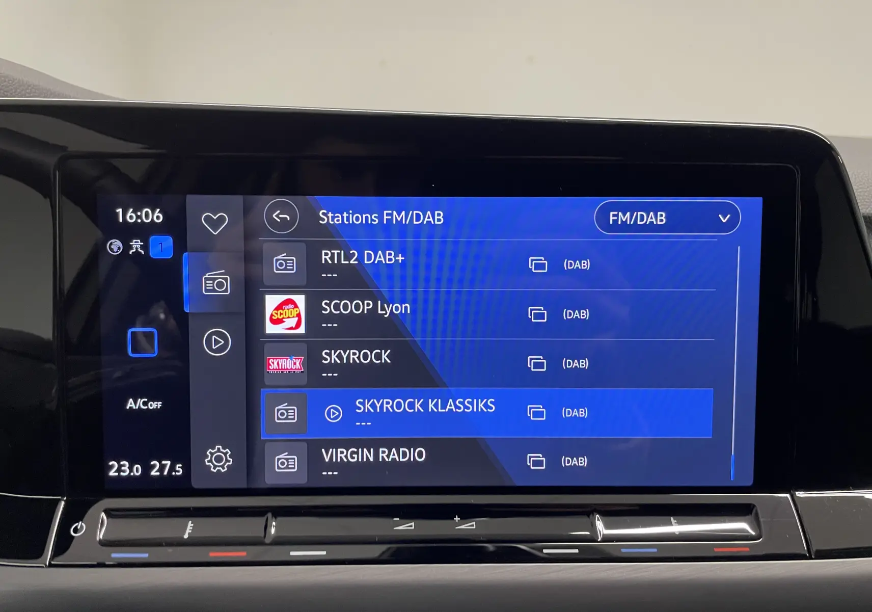 Écran tactile central affichant les stations FM/DAB dans l'habitacle d'une Volkswagen Golf blanche 2023.