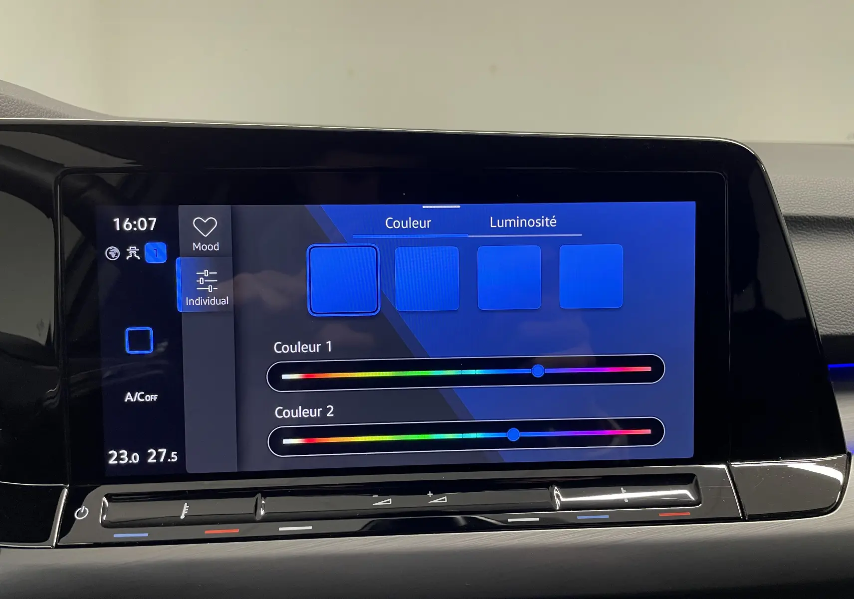 Écran tactile intérieur de la Volkswagen Golf 1.5 eTSI 2023 montrant les réglages de couleur et luminosité de l'ambiance lumineuse.