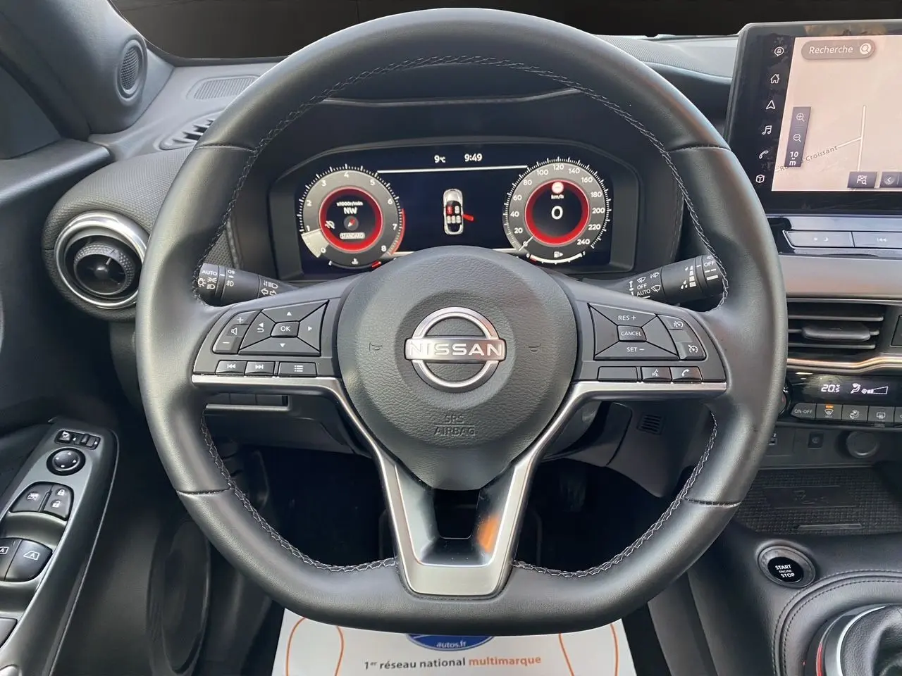 Vue rapprochée du volant noir et du tableau de bord digital du Nissan Juke 2025 avec écran tactile et commandes intégrées.