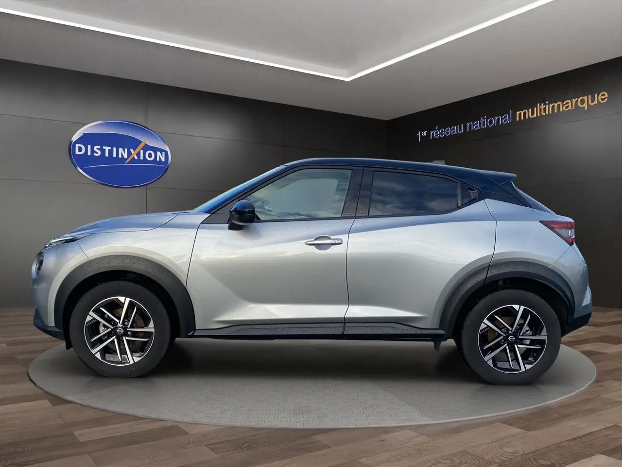 Vue de profil côté gauche d'un Nissan Juke 2025 gris perle avec toit noir et jantes alliage 17 pouces.