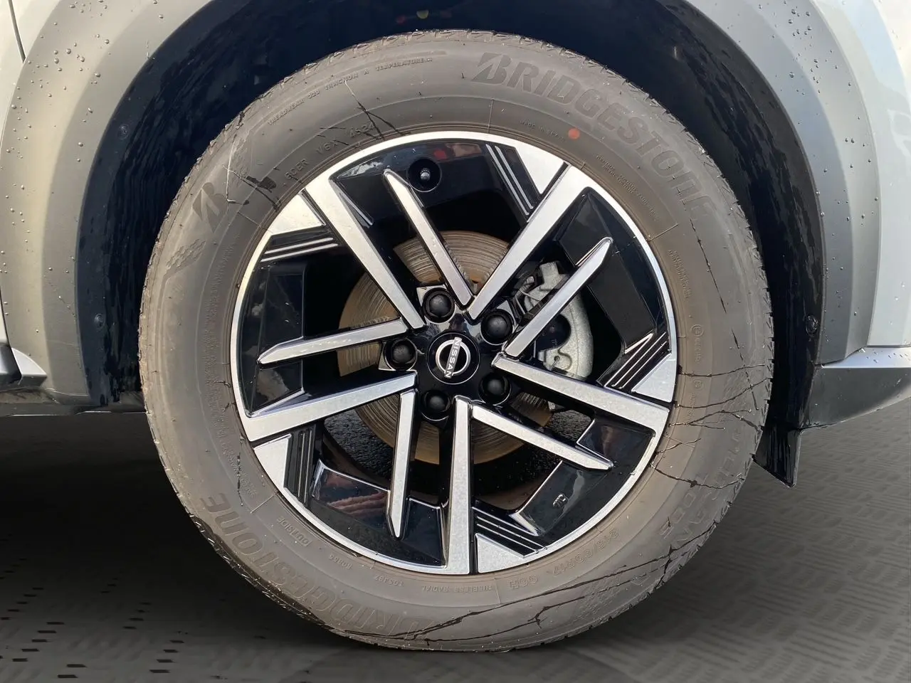 Gros plan sur la jante alliage 17'' noire et argent du Nissan Juke gris perle, côté avant droit.