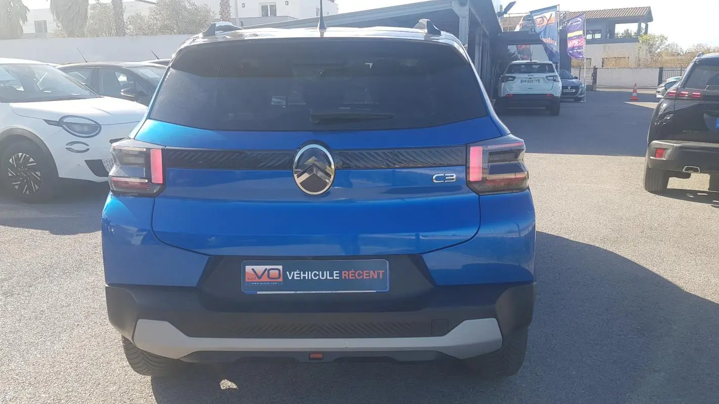 Vue arrière d'une Citroën C3 bleu foncé 2024 avec barres de toit et jantes alliage 17 pouces.
