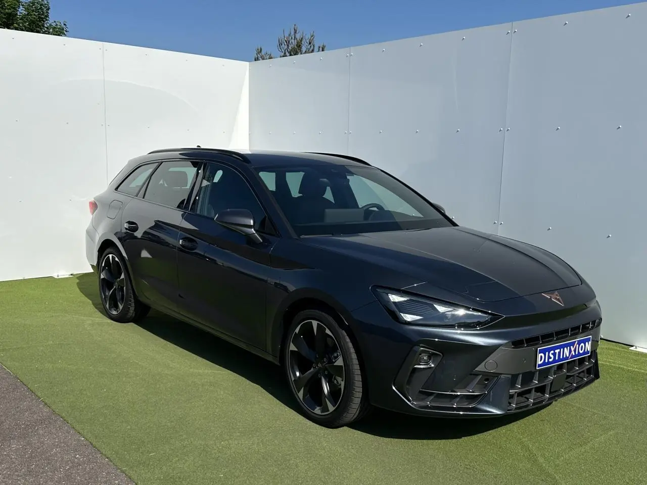 Vue 3/4 avant droite d'une CUPRA Leon Sportstourer 2025 en gris magnétique avec jantes alliage noires et signature lumineuse Tri-LED.