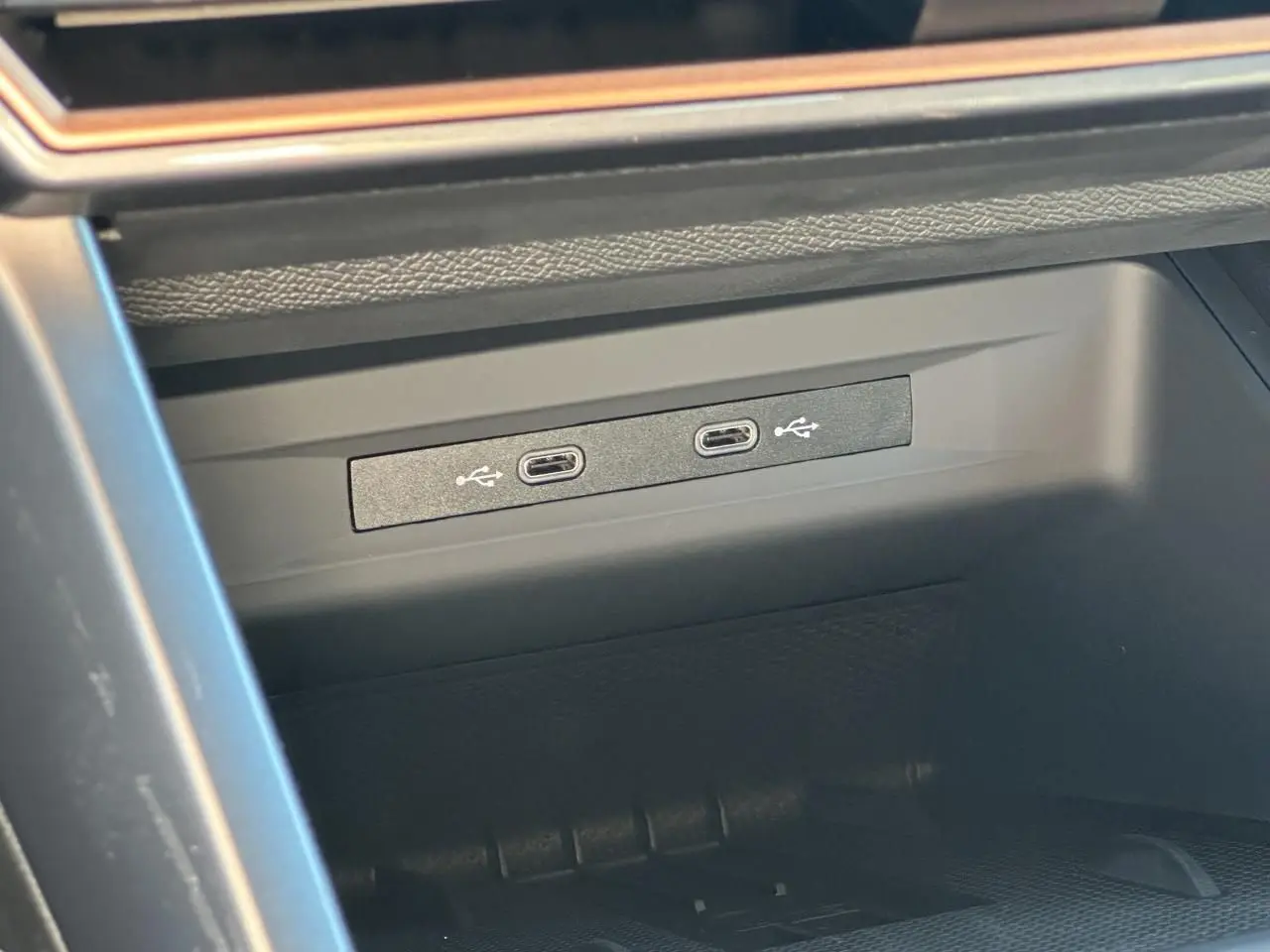Gros plan sur deux prises USB-C éclairées dans la console centrale d'une CUPRA Leon Sportstourer gris magnétique 2025.