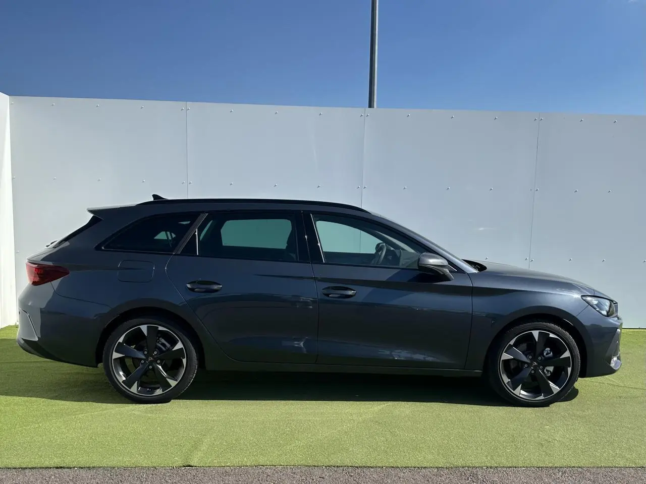 Profil côté gauche d'une CUPRA Leon Sportstourer 2025 gris magnétique avec jantes alliage noires et toit noir.