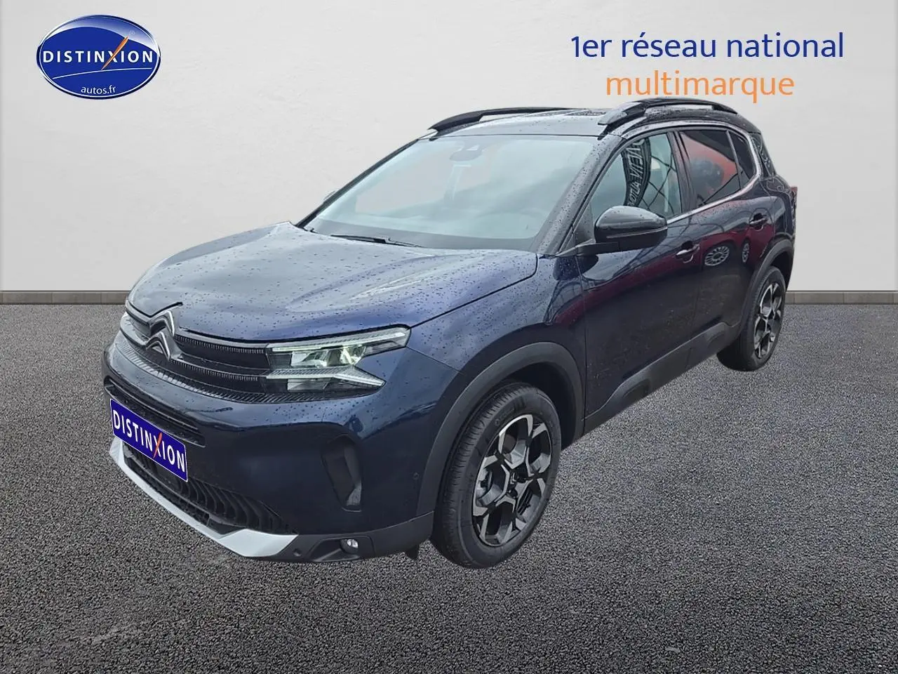 Citroën C5 Aircross bleu eclipse vue 3/4 avant droit avec jantes alliage et phares LED allumés sous la pluie.