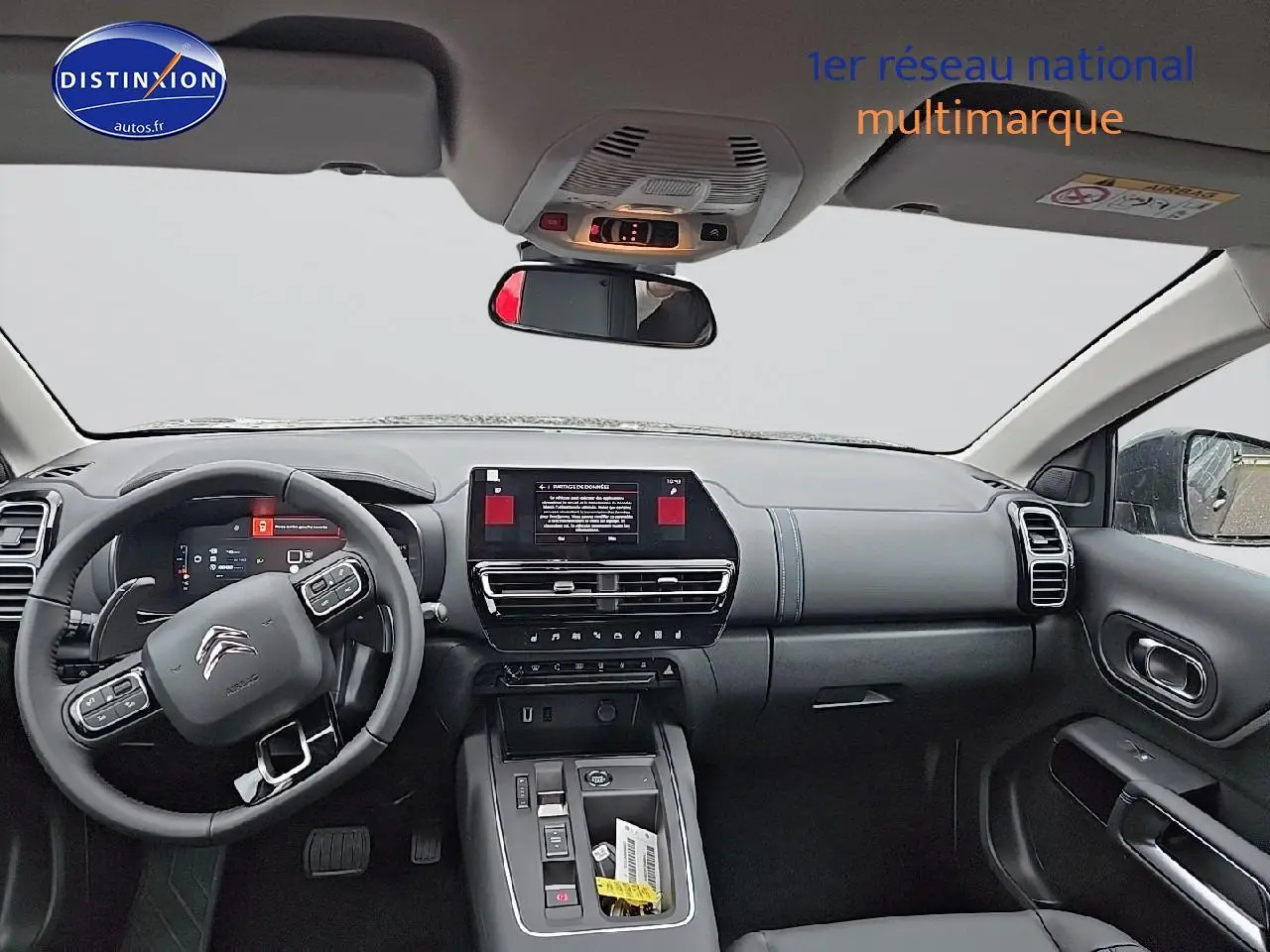 Vue intérieure avant du Citroën C5 Aircross 2025, tableau de bord et volant avec écran tactile central visible.