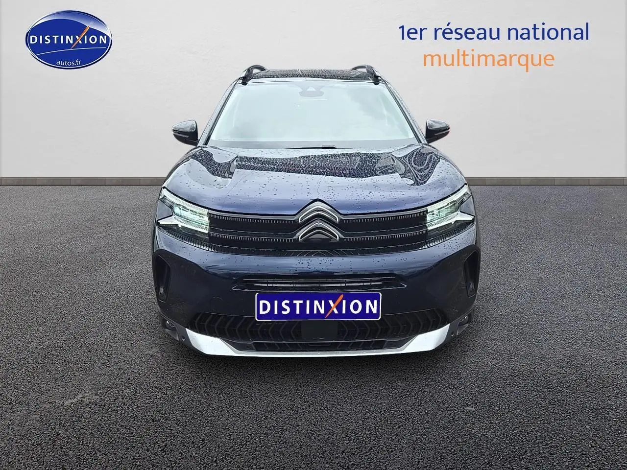 Vue frontale d'un Citroën C5 Aircross bleu eclipse 2025 avec phares LED allumés et logo distinctif au centre.