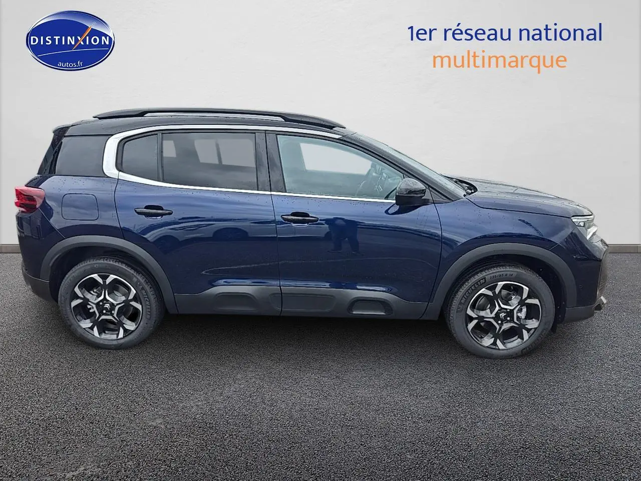 Profil droit d'un Citroën C5 Aircross Bleu Eclipse 2025 avec jantes alliage et barres de toit noires.