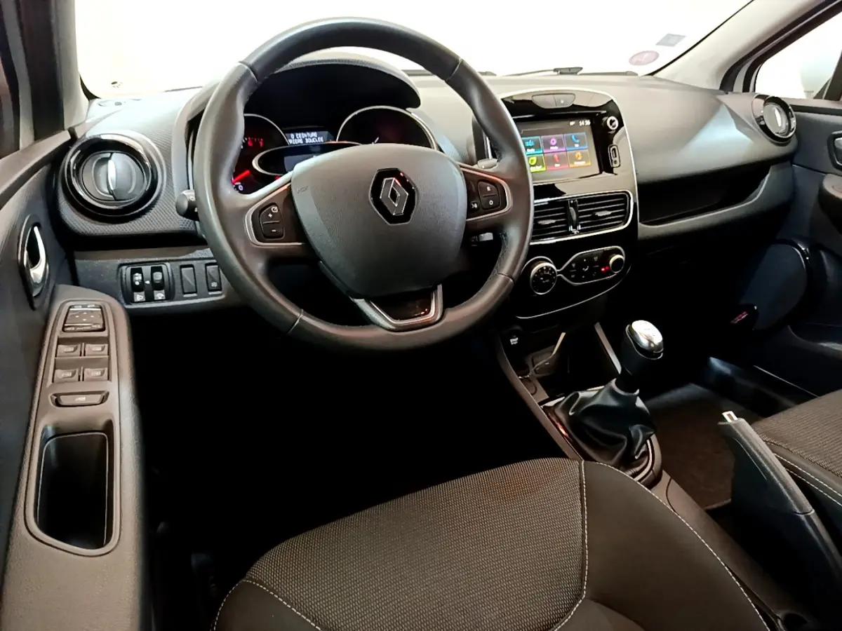 Intérieur de Renault Clio Business TCe 90 2019 vu côté conducteur, volant cuir et écran tactile central visible.