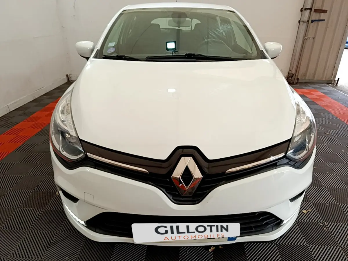 Vue frontale d'une Renault Clio Business TCe 90 blanche, avec logo Renault et phares LED visibles.