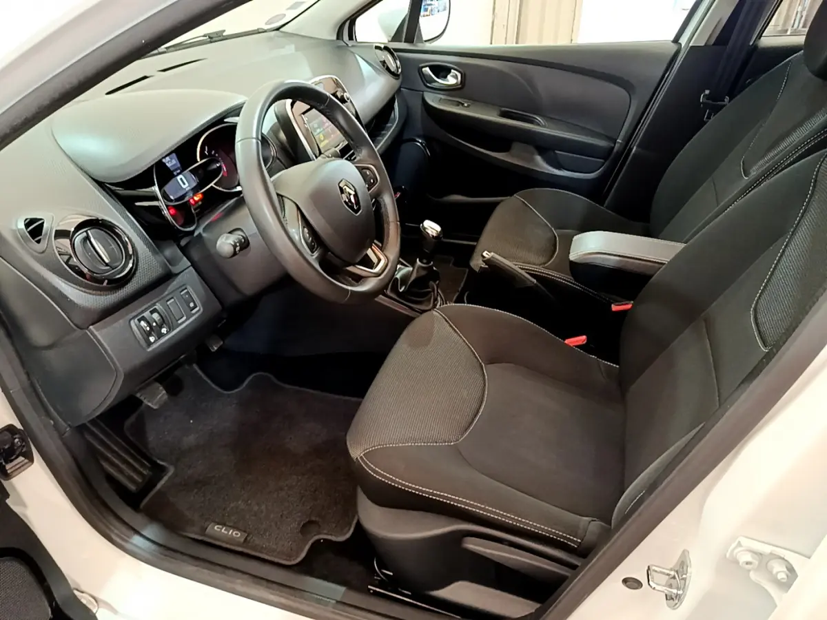 Intérieur avant droit d'une Renault Clio Business TCe 90 blanche, volant cuir, tableau de bord avec écran tactile et boîte manuelle.