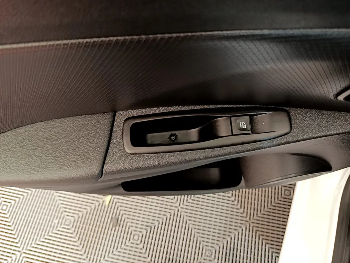 Gros plan sur la commande de lève-vitre côté conducteur de la Renault Clio Business TCe 90 blanche de 2019.