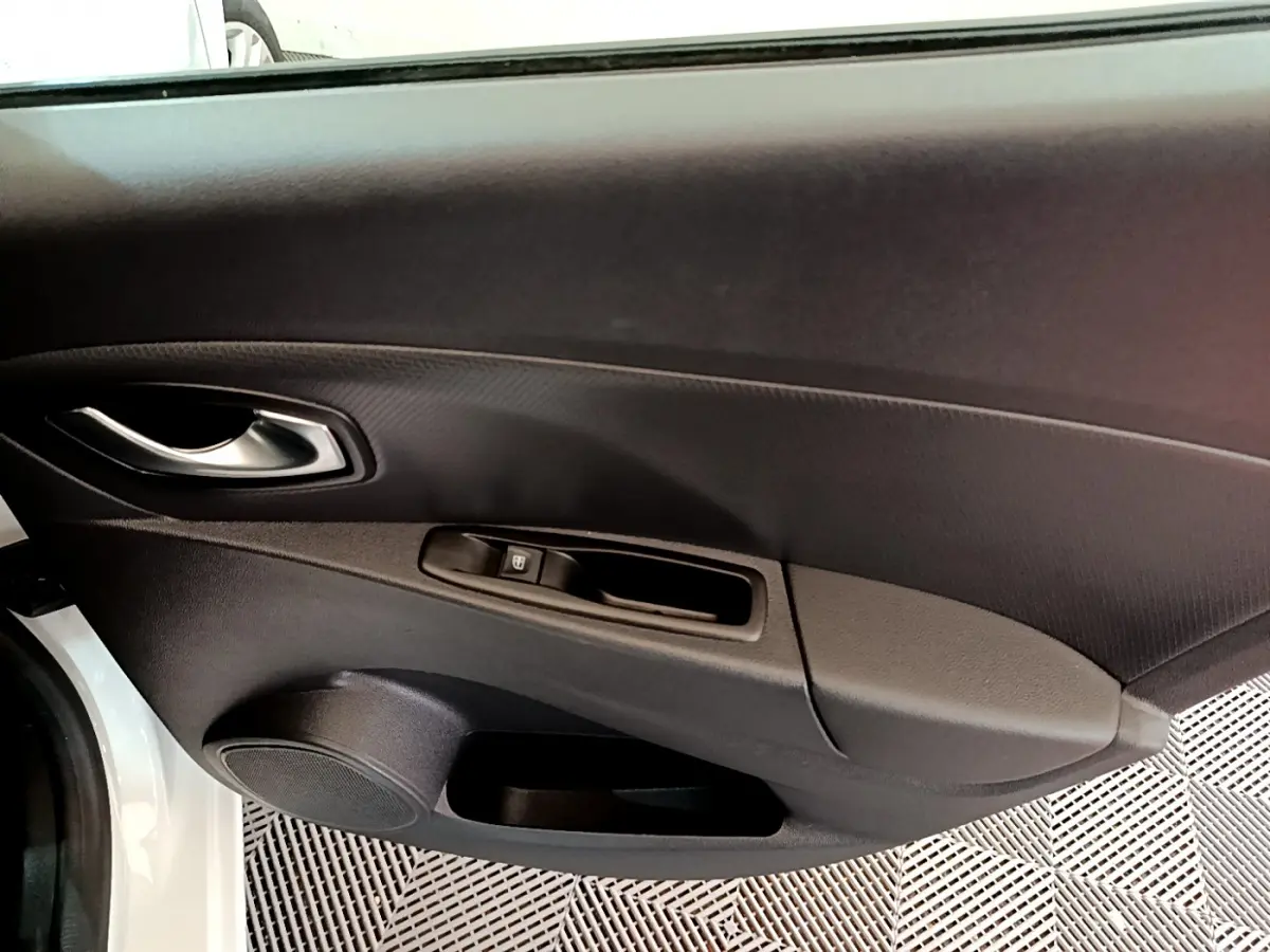 Vue intérieure du panneau de porte côté conducteur de la Renault Clio Business TCe 90 blanc, 2019, avec poignée argentée et commande de vitre.