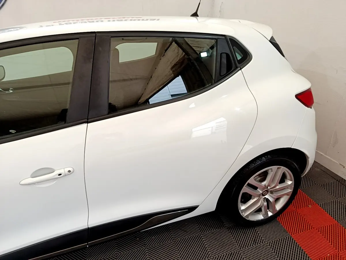 Profil arrière droit d'une Renault Clio Business TCe 90 blanche, mettant en valeur la porte arrière et la jante alliage.