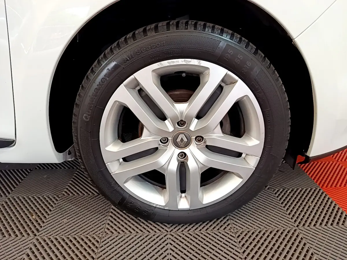 Gros plan sur la roue avant droite blanche d'une Renault Clio Business TCe 90 de 2019 avec jante alliage argentée.