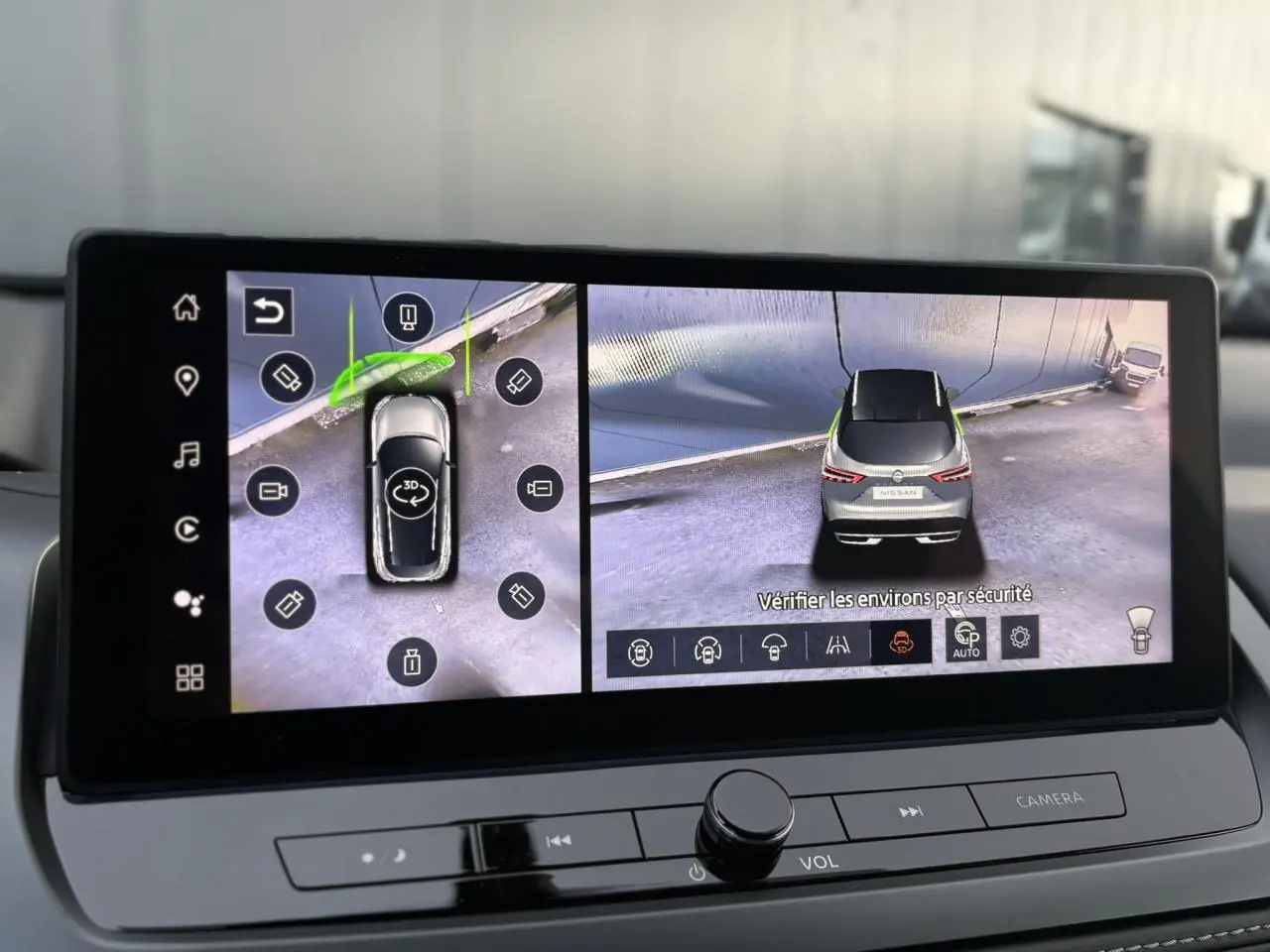 Écran intérieur affichant la vue 360° du Nissan Qashqai gris Ceramic vu de dessus et de l'arrière en caméra de recul.
