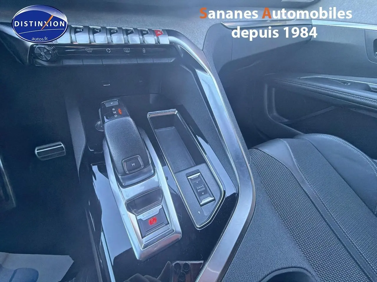 Vue rapprochée de la console centrale noire avec levier de vitesses et bouton Drive Mode du Peugeot 3008 bleu 2023.