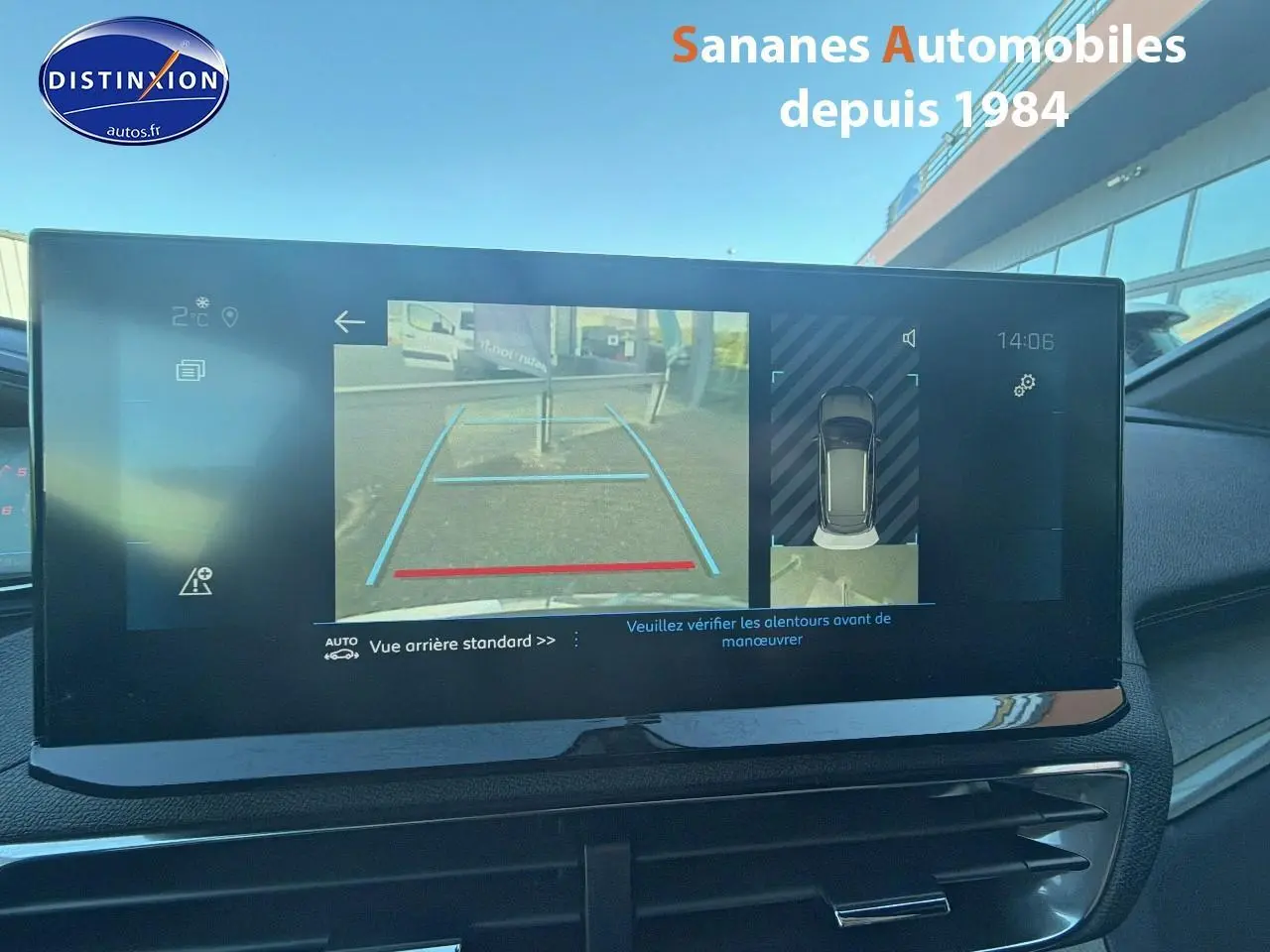 Écran tactile intérieur affichant la caméra de recul et l'aide au stationnement du Peugeot 3008 bleu, vue avant du tableau de bord.