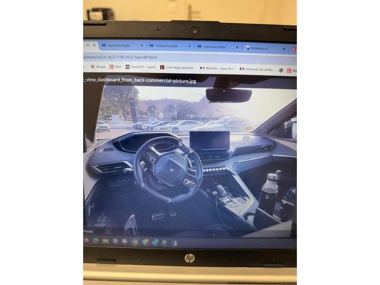 Vue 3/4 avant d’un Peugeot 3008 bleu métallisé garé devant un mur en briques grises.