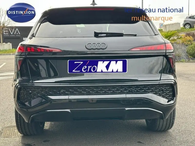 Vue arrière d'un Audi Q3 2.0 TDI 150ch S line noir Mythique métallisé avec feux arrière LED et logo Audi visible.