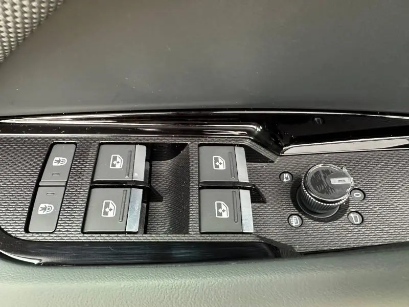 Détail des commandes des vitres et rétroviseurs côté conducteur de l'Audi Q3 noir Mythique métallisé, finition S line.