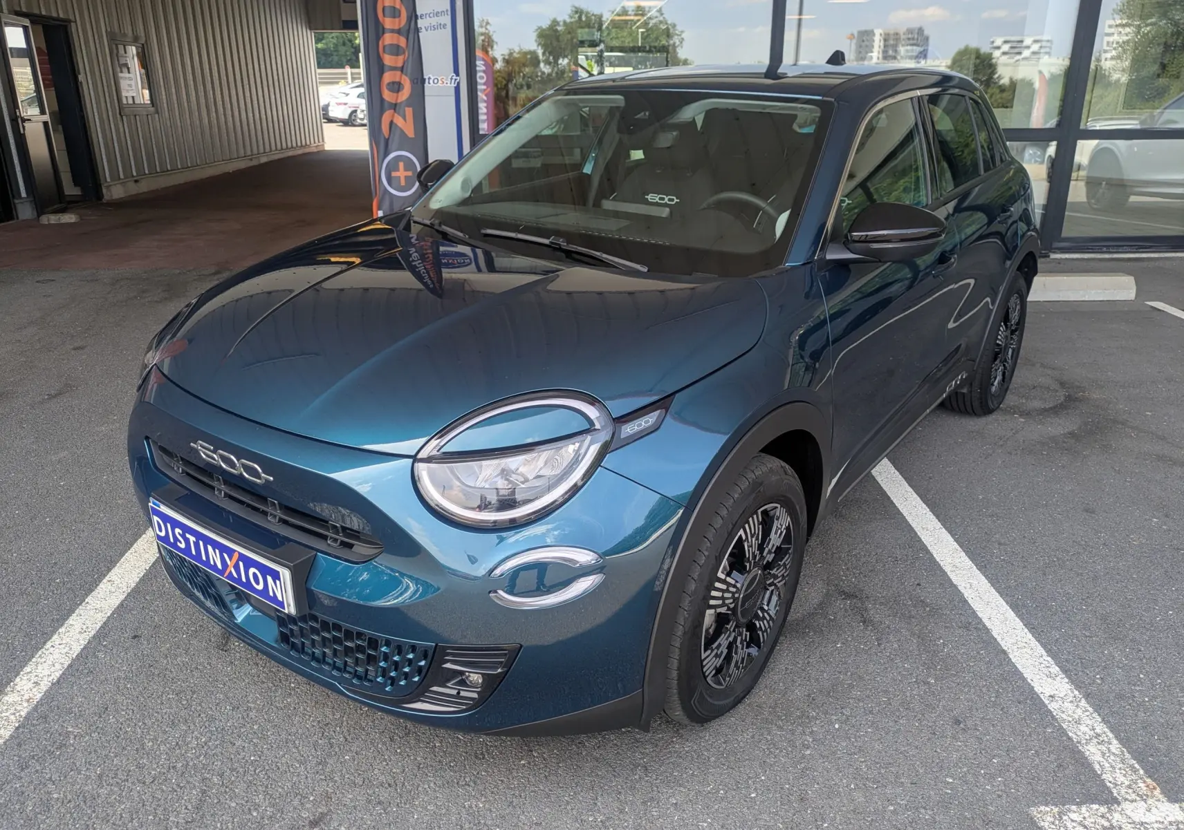 Vue 3/4 avant droite d'une FIAT 600 1.2 Hybrid bleu Sea of Italy avec jantes noires et toit noir.