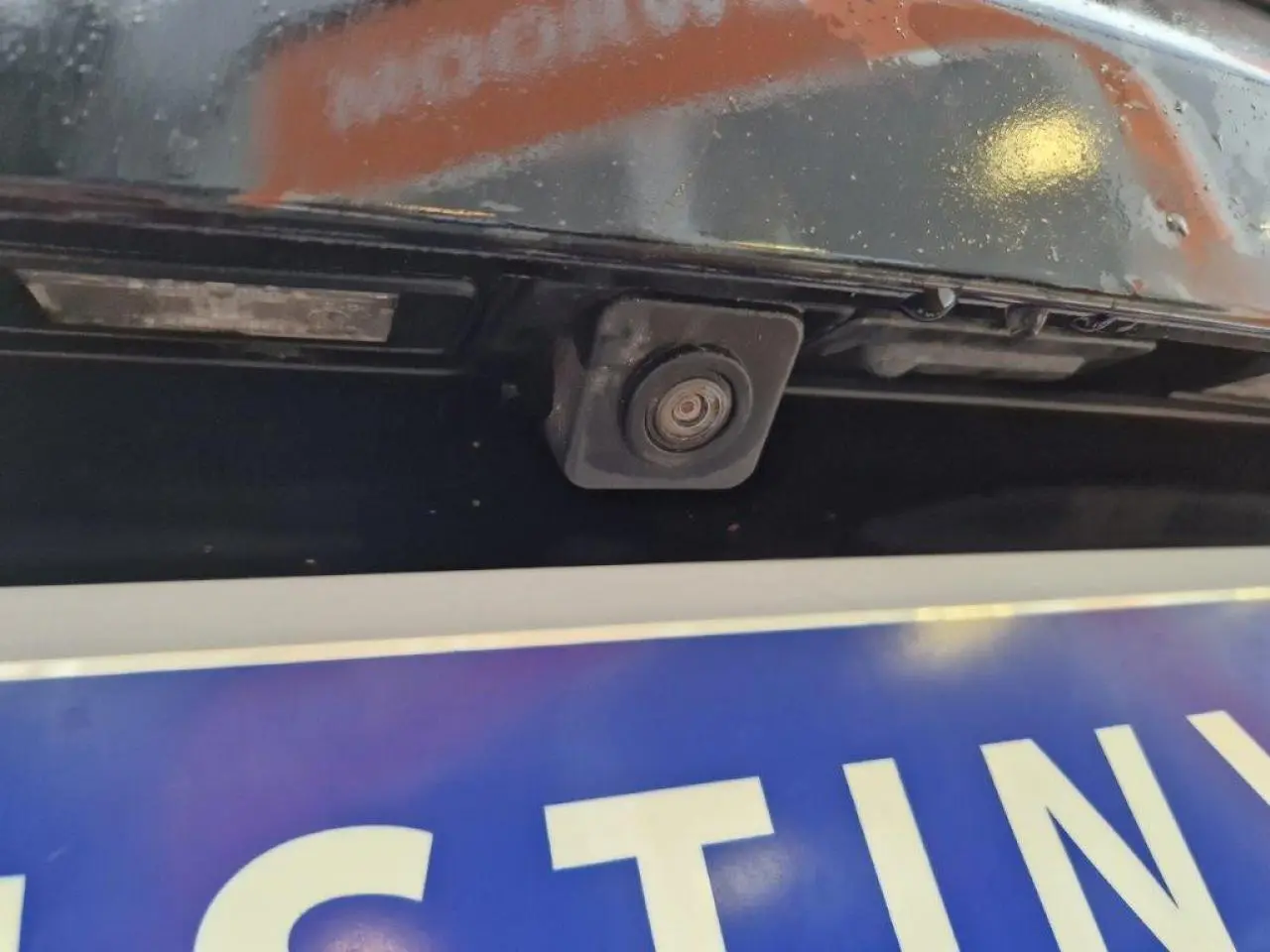 Gros plan sur la caméra de recul intégrée au hayon arrière d’un Peugeot 3008 noir de 2019.