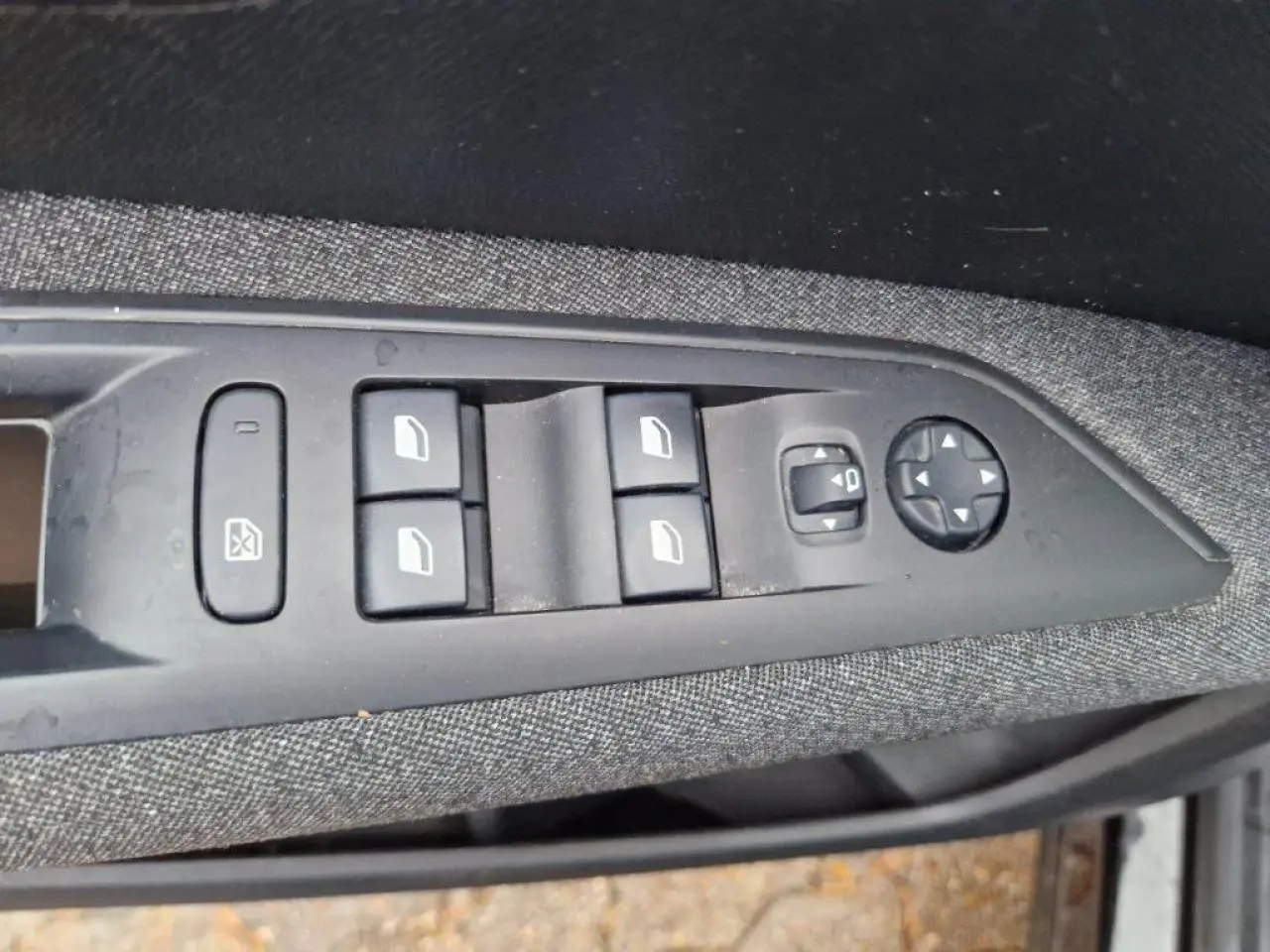 Commandes des vitres électriques et réglage des rétroviseurs sur la portière côté gauche d'un Peugeot 3008 noir 2019.