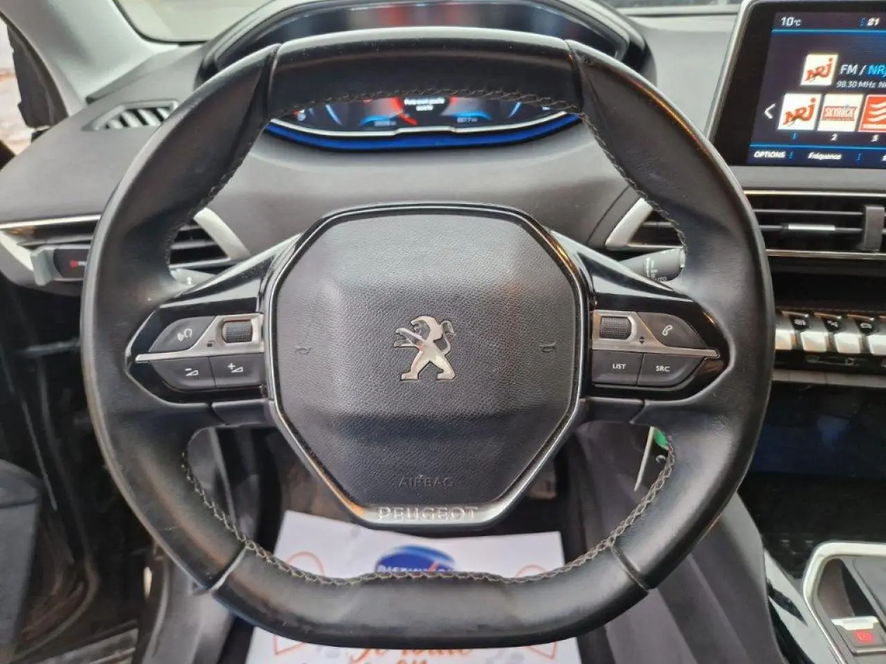 Volant cuir noir de Peugeot 3008 2019 vu de face, avec commandes intégrées et tableau de bord numérique en arrière-plan.