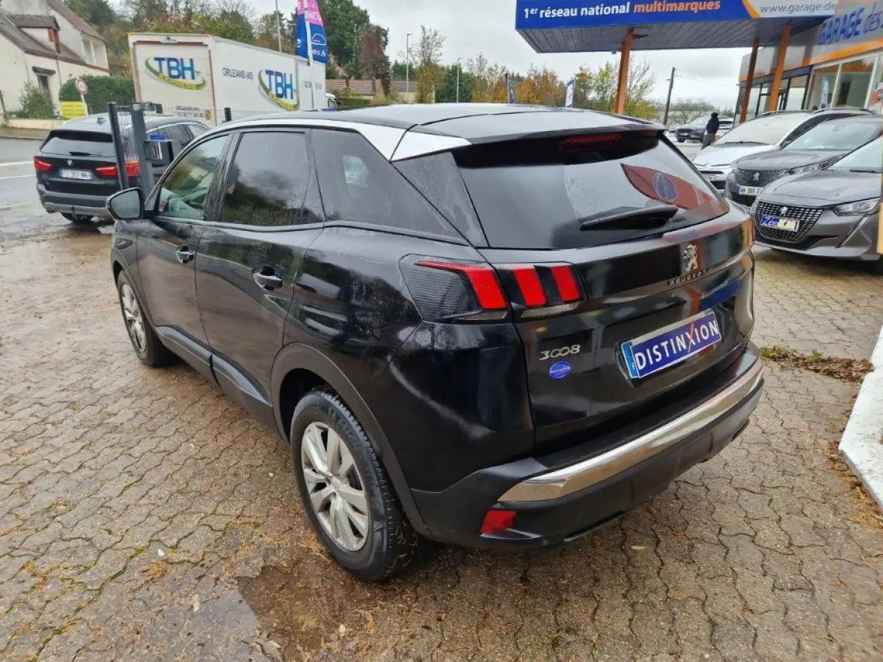 Peugeot 3008 noir vue 3/4 arrière côté gauche, avec feux arrière à griffes rouges et jantes alliage 17 pouces.