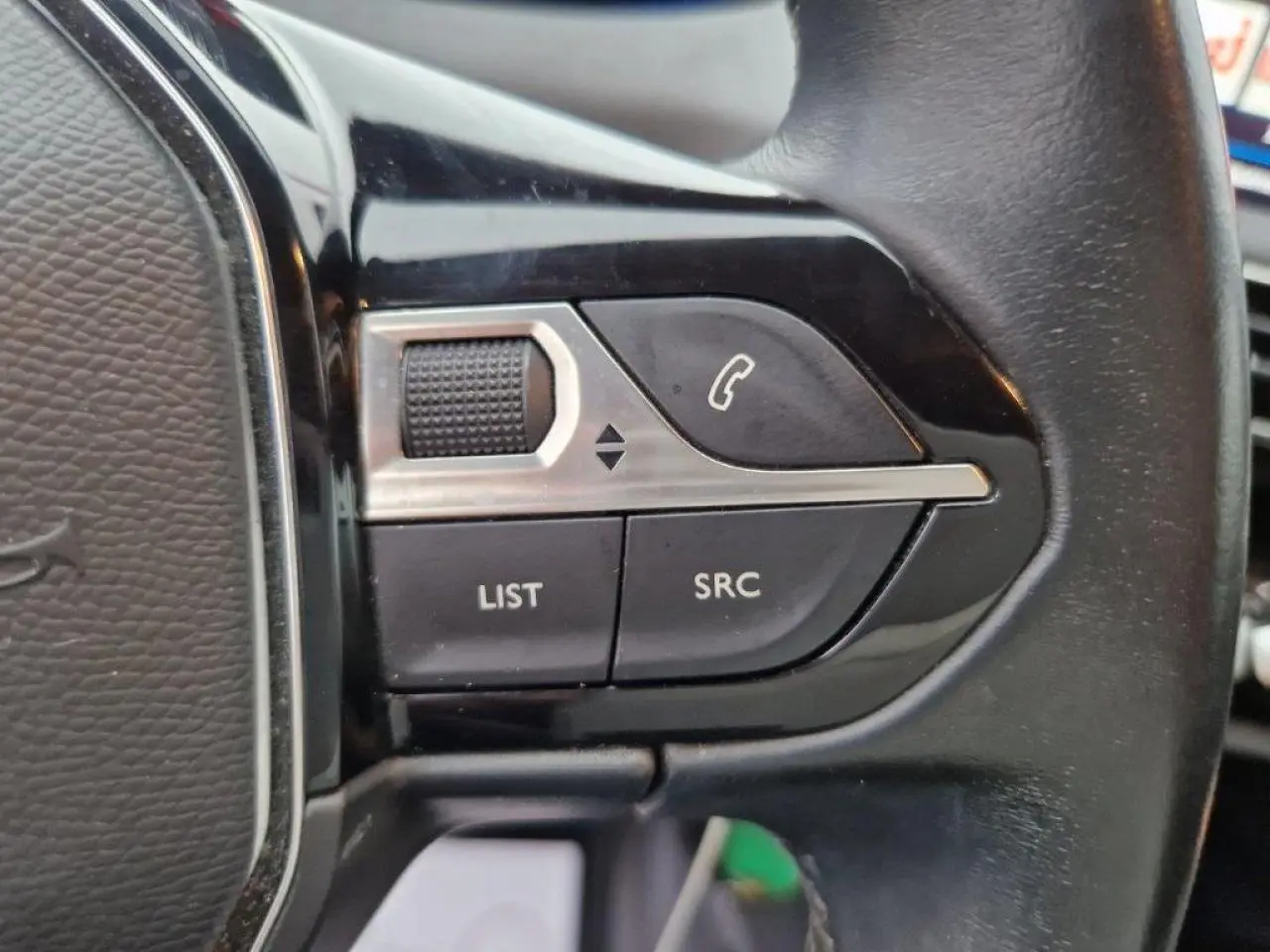 Gros plan sur les commandes gauche du volant cuir noir du Peugeot 3008 2019 avec boutons LIST et SRC visibles.