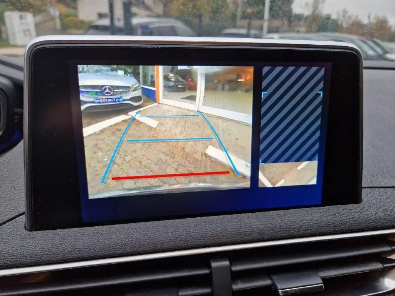 Écran tactile du Peugeot 3008 noir montrant la caméra de recul avec aides au stationnement activées.