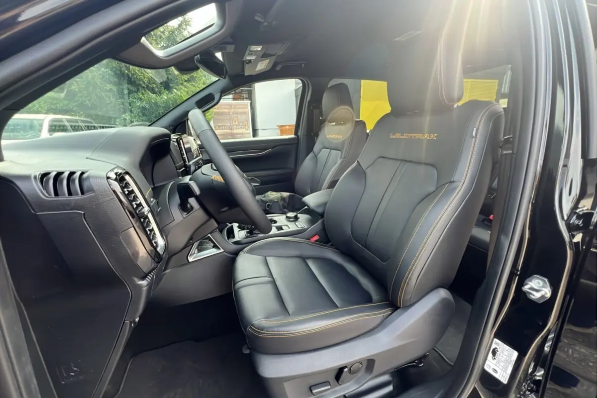 Intérieur côté conducteur du Ford Ranger 2025 noir agate, sièges Wildtrak en cuir noir avec surpiqûres jaunes visibles.