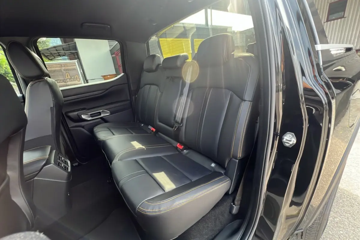 Vue intérieure côté droit sur la banquette arrière en cuir noir avec surpiqûres jaunes du Ford Ranger 2025 Wildtrak Plus.