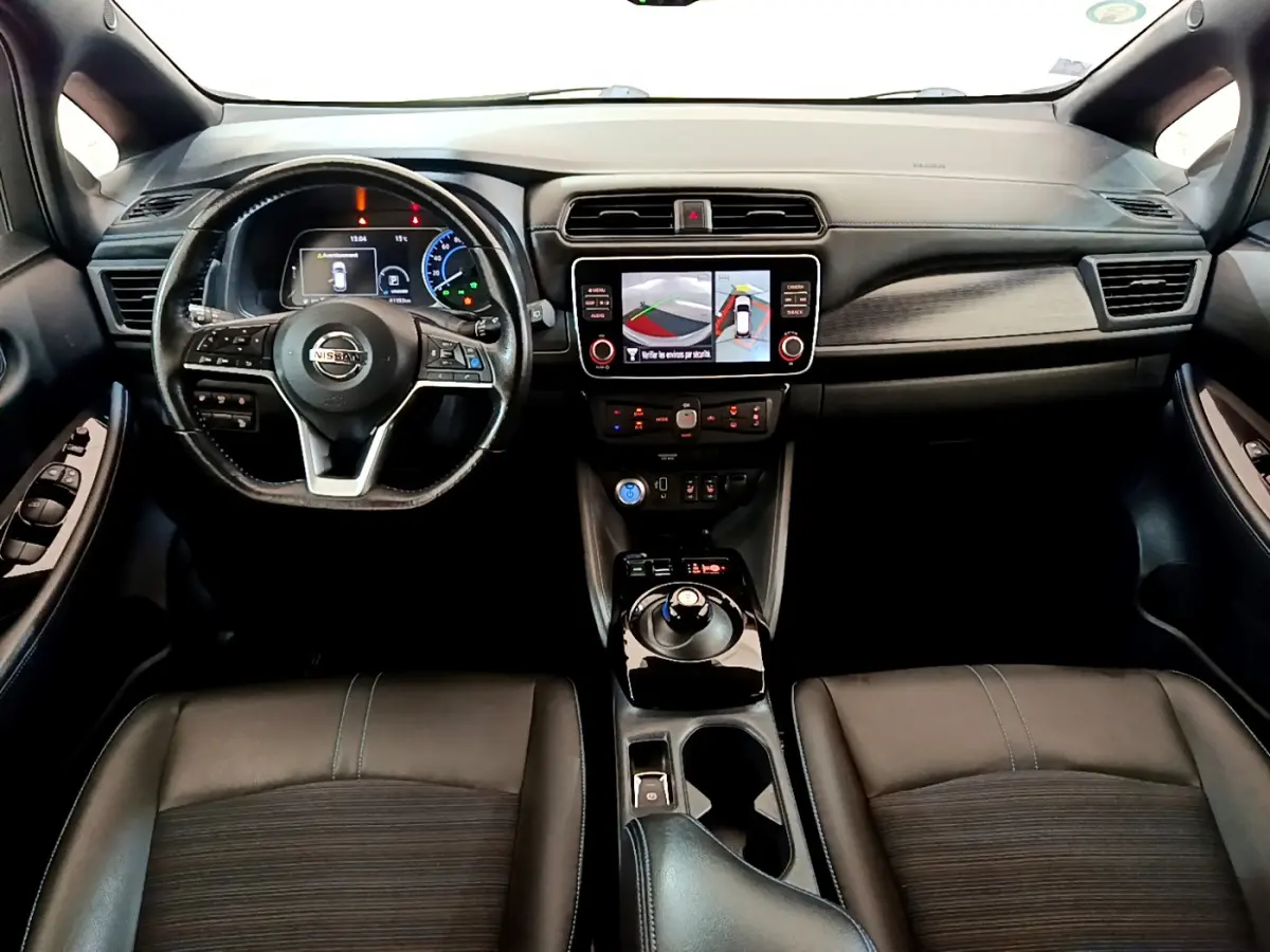 Vue intérieure avant du Nissan Leaf 62 kWh avec tableau de bord noir et écran tactile central affichant la caméra 360°