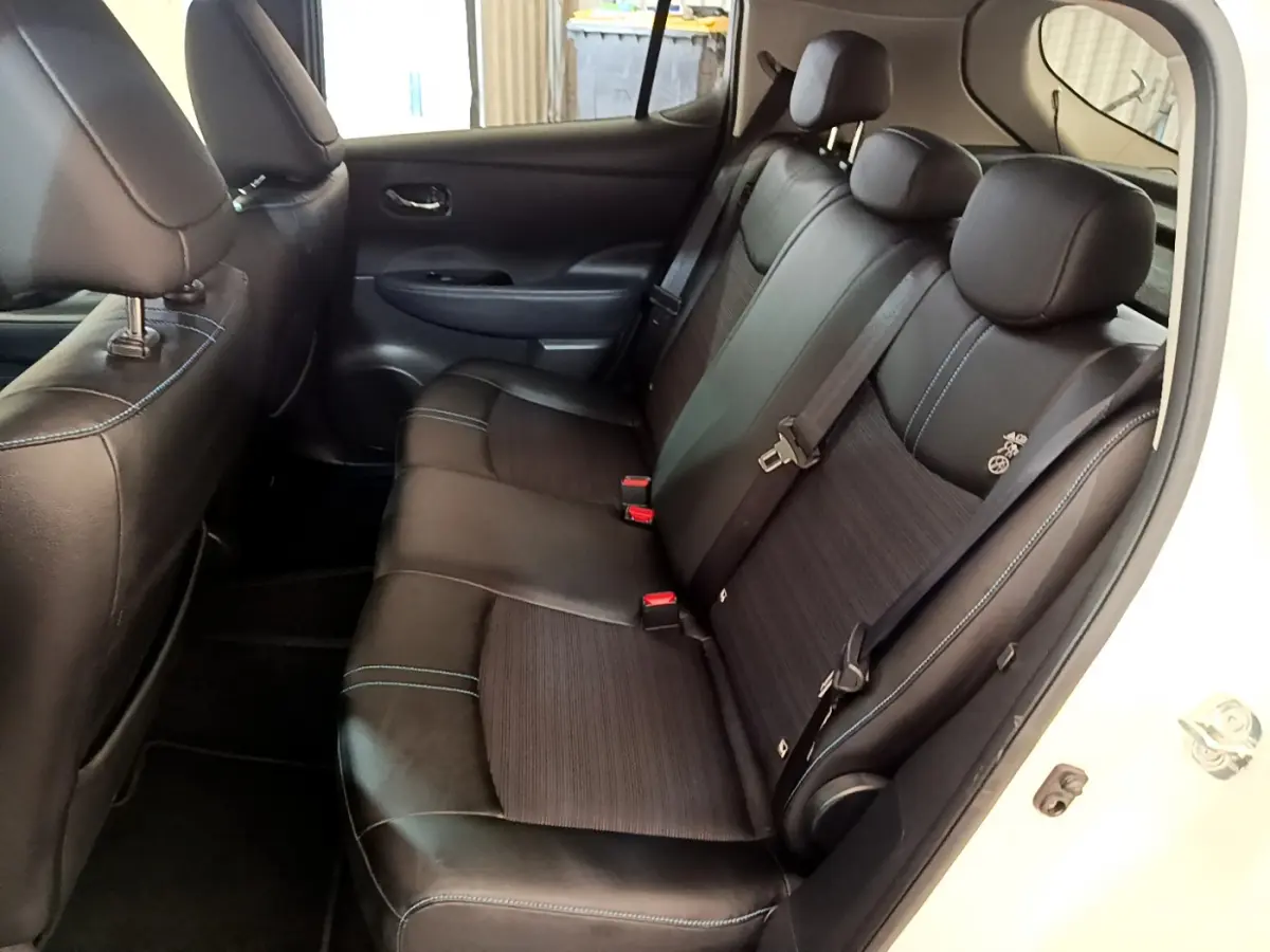 Vue côté droit de la banquette arrière noire avec surpiqûres bleues du Nissan Leaf blanc 62 kWh Business+ 2020 électrique.