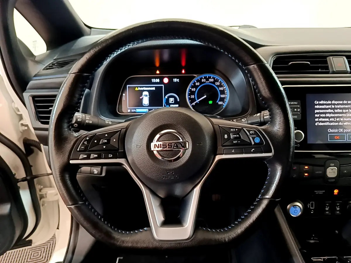 Vue rapprochée du volant cuir noir de la Nissan Leaf 62 kWh 2020 avec tableau de bord numérique et écran tactile.