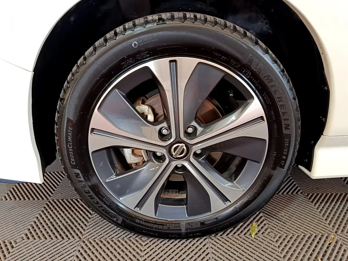 Gros plan sur la roue avant droite d'une Nissan Leaf blanche 2020 avec jante alliage bicolore et pneu Michelin